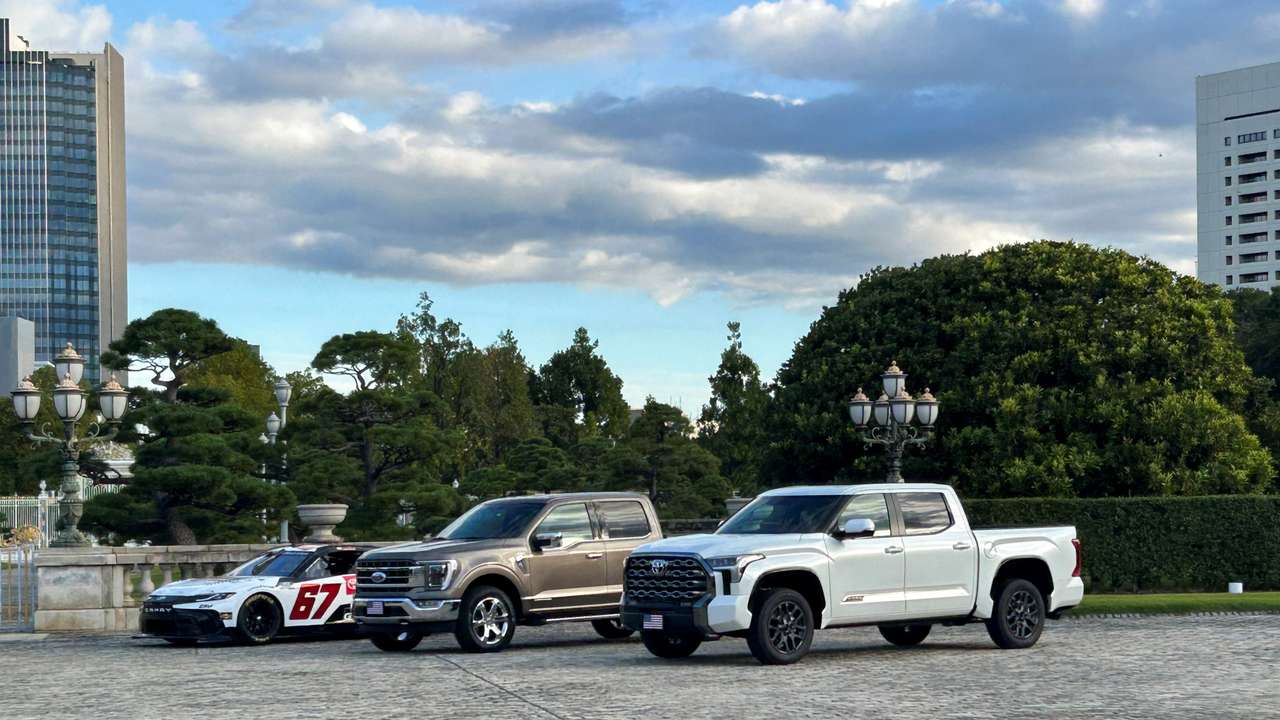 A Ford F-150 and a Toyota pickup truck are parked outside of Akasaka Palace, in Tokyo