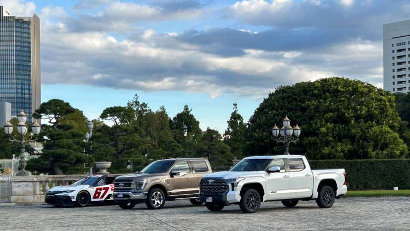 A Ford F-150 and a Toyota pickup truck are parked outside of Akasaka Palace, in Tokyo