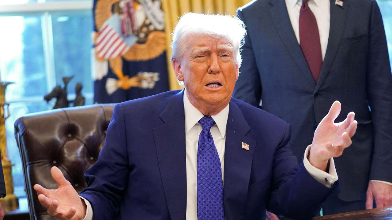 U.S. President Donald Trump signs an executive order in the Oval Office at the White House in Washington, D.C.