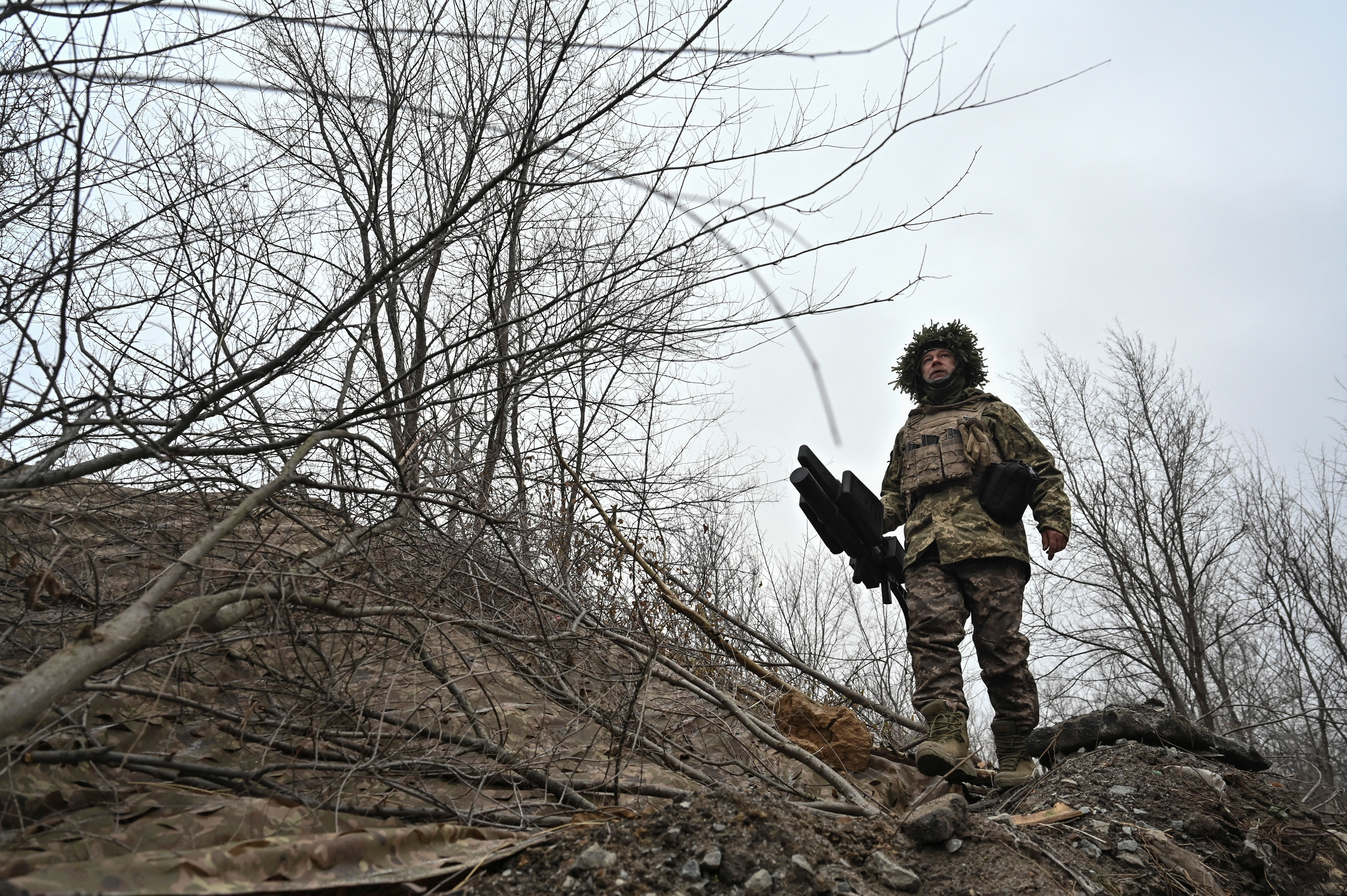 A Ukrainian serviceman walks at a position with an anti-drone rifle in a front line, in Zaporizhzhia region