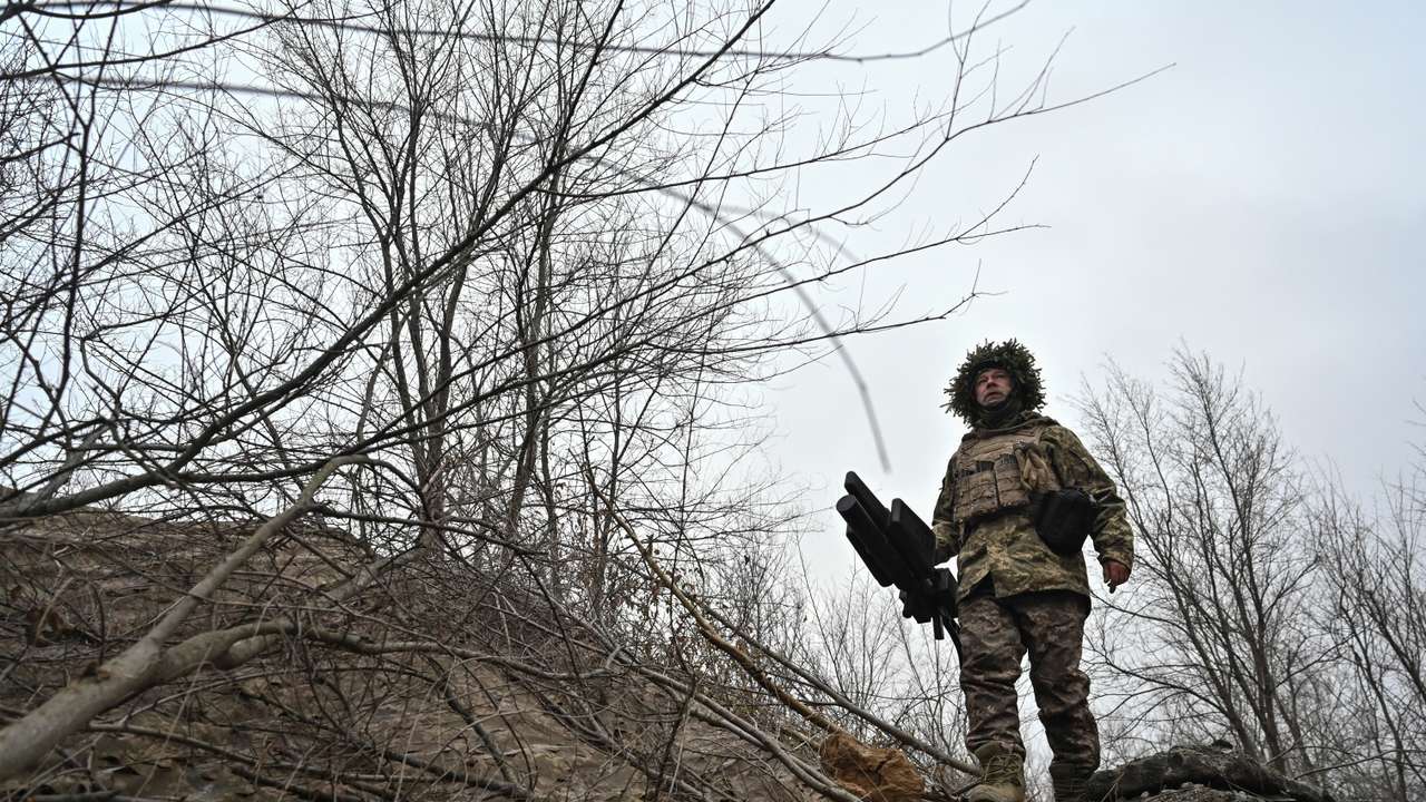 A Ukrainian serviceman walks at a position with an anti-drone rifle in a front line, in Zaporizhzhia region