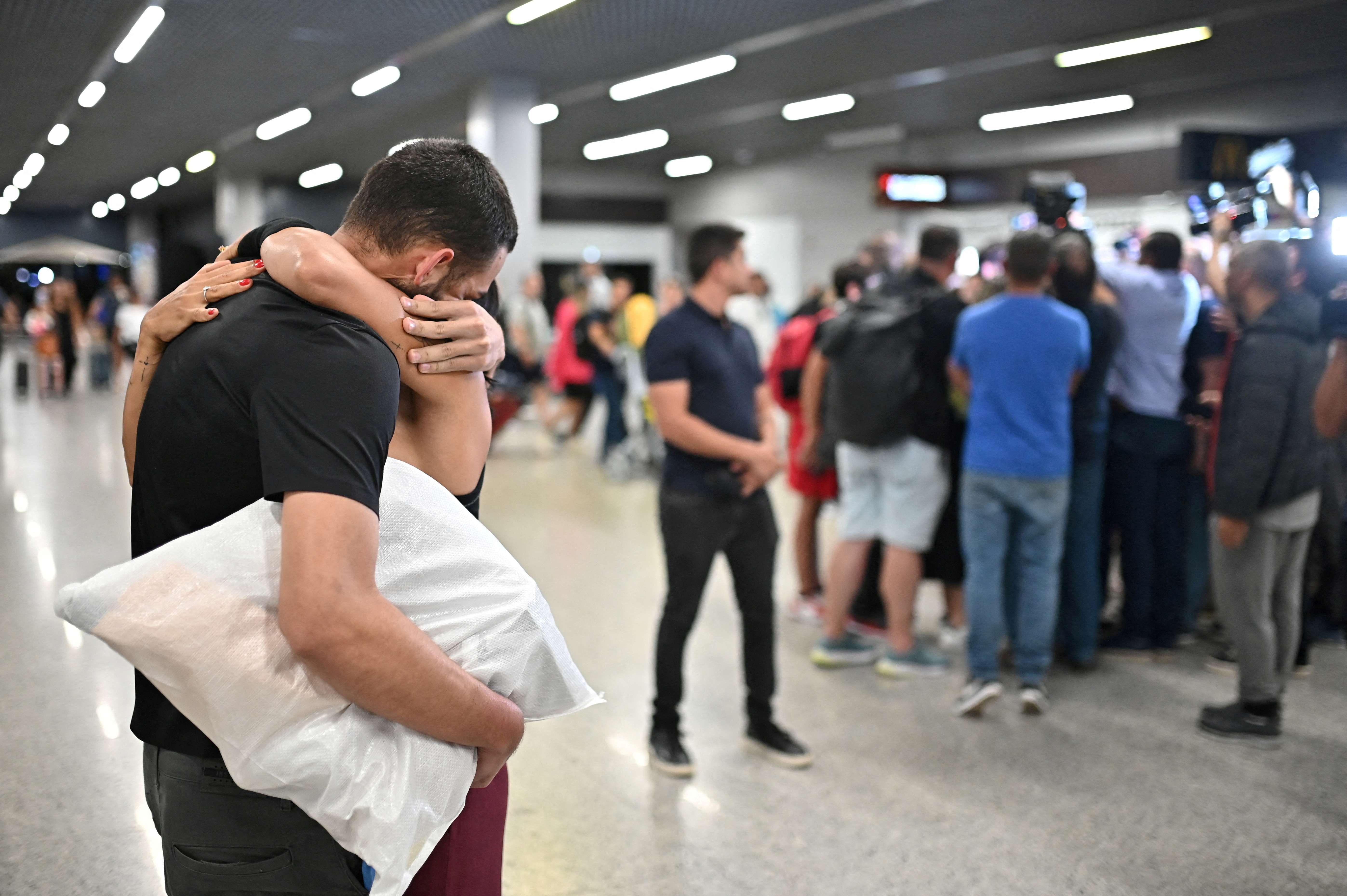 FILE PHOTO: A Brazilian migrant, deported from the U.S. under President Donald Trump's administration, is welcomed by his relative at the Confins airport in Belo Horizonte