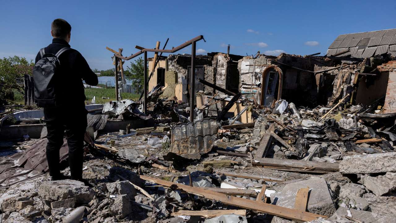 A man surveys the damage of a house that was hit during a Russian missile strike in the Kyiv region