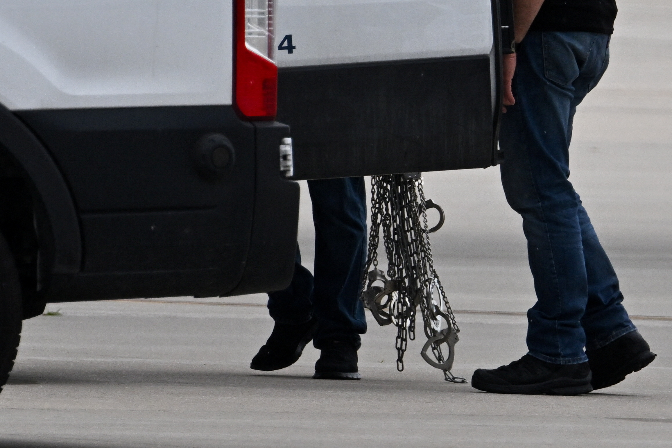 Migrants detained by U.S. Immigration and Customs Enforcement (ICE) board a plane at Gary/Chicago International Airport