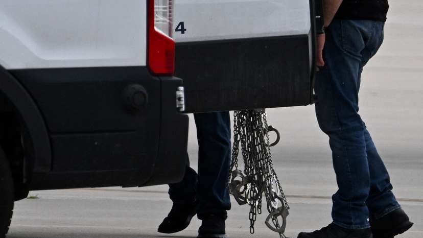 Migrants detained by U.S. Immigration and Customs Enforcement (ICE) board a plane at Gary/Chicago International Airport