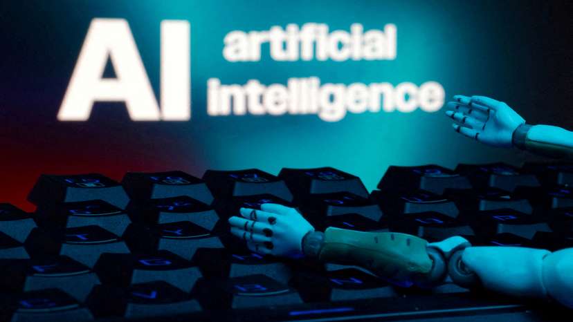 FILE PHOTO: Illustration shows message reading "AI artificial intelligence", keyboard and robot hands