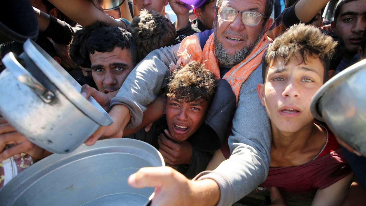 Gazans scramble to receive food cooked by a charity kitchen amid a hunger crisis