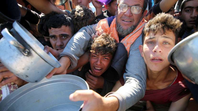 Gazans scramble to receive food cooked by a charity kitchen amid a hunger crisis