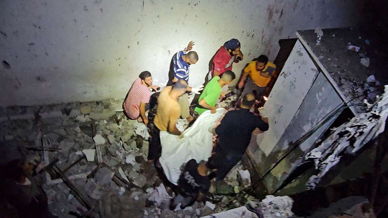 People carry the body of a Palestinian killed in an Israeli strike on a school sheltering displaced people in Nuseirat refugee camp in the central Gaza Strip