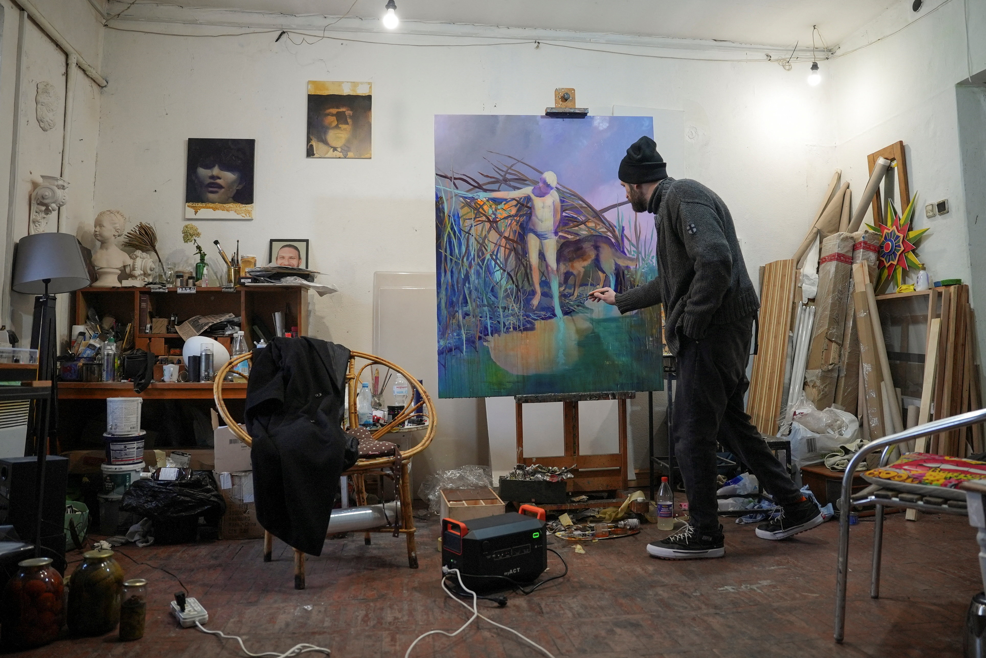 Ukrainian artist works at his studio during a power blackout in Kyiv
