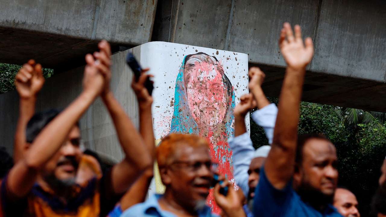 A mural of Prime Minister Sheikh Hasina is seen vandalised by protesters as people celebrate her resignation in Dhaka
