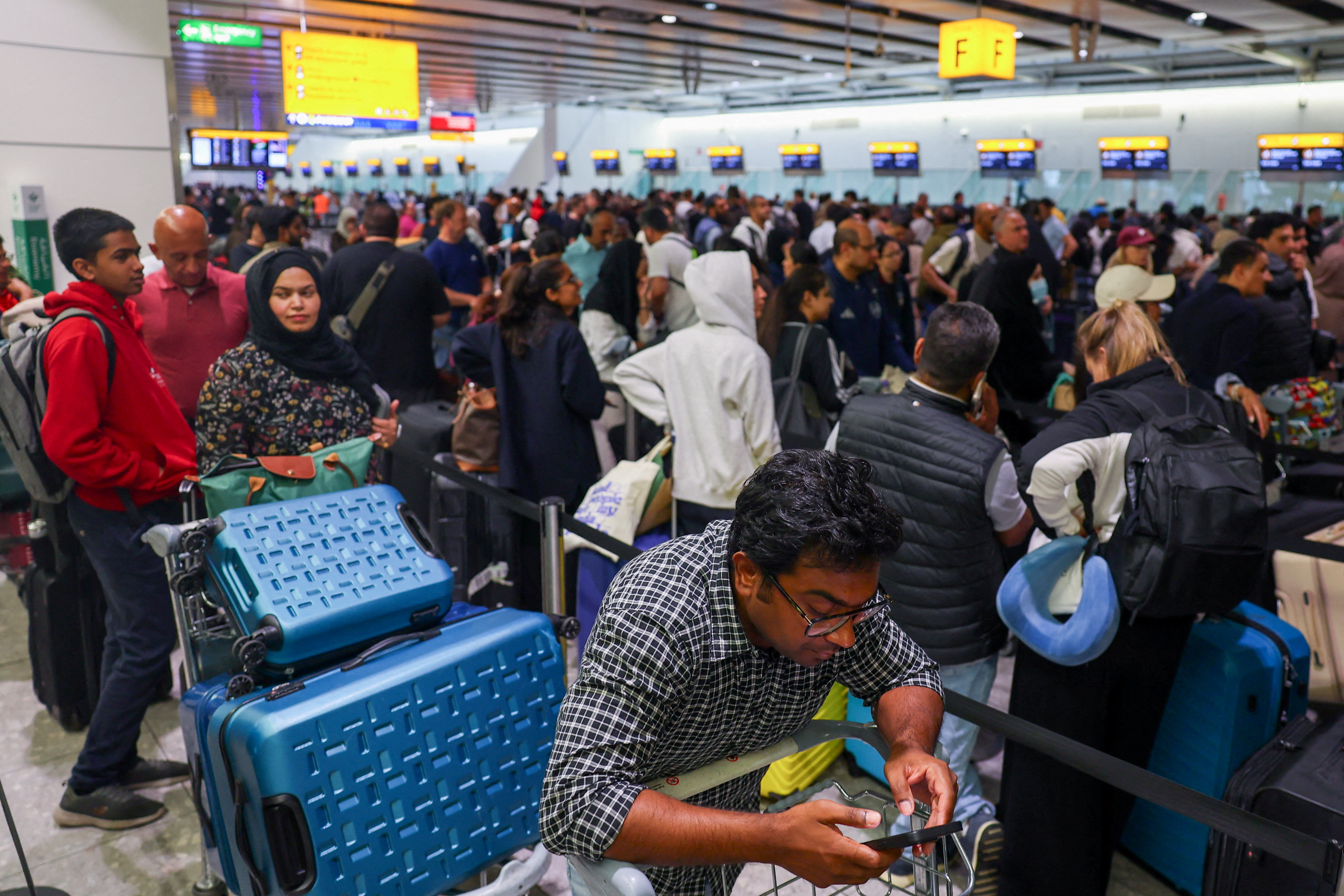 FILE PHOTO: Travellers at Heathrow Airport amid cyberattack disruptions, in Greater London