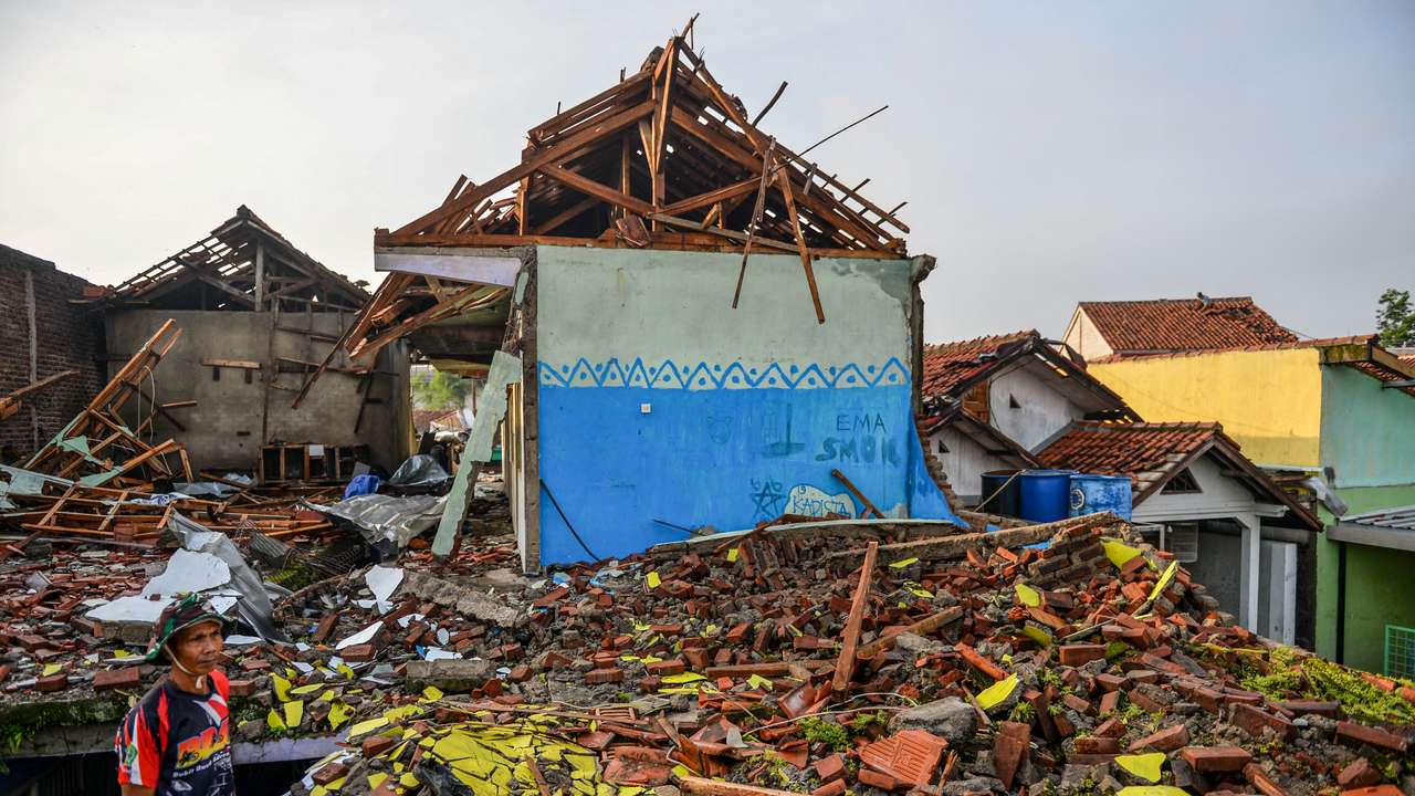 A man stands near damaged houses following a tornado at Sukadana village in Sumedang
