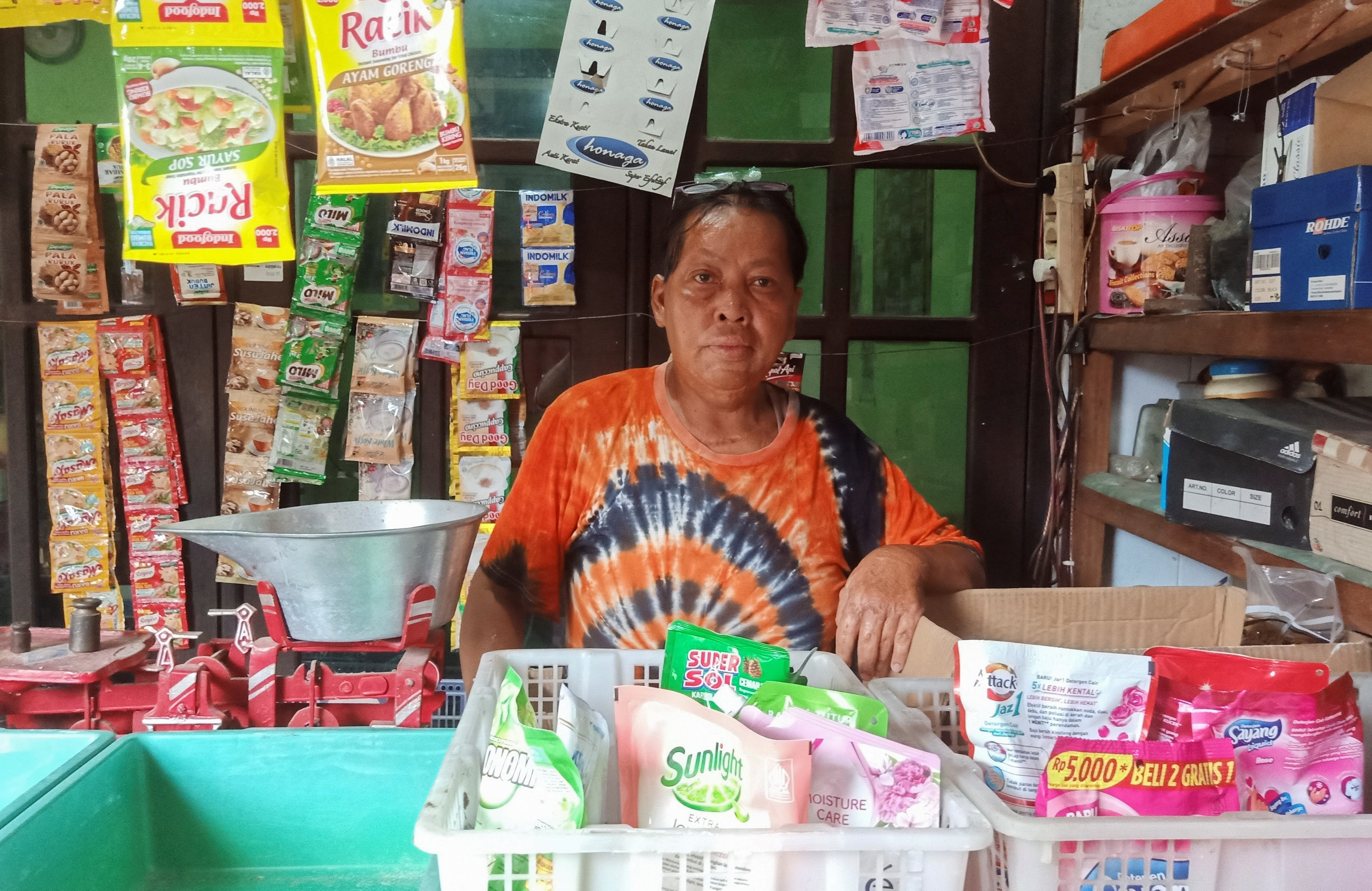 Chusnul Chotimah, a Bali bombing survivor poses for pictures inside his stall in Sidoarjo