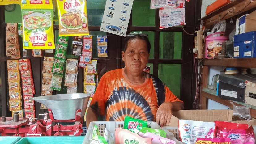 Chusnul Chotimah, a Bali bombing survivor poses for pictures inside his stall in Sidoarjo