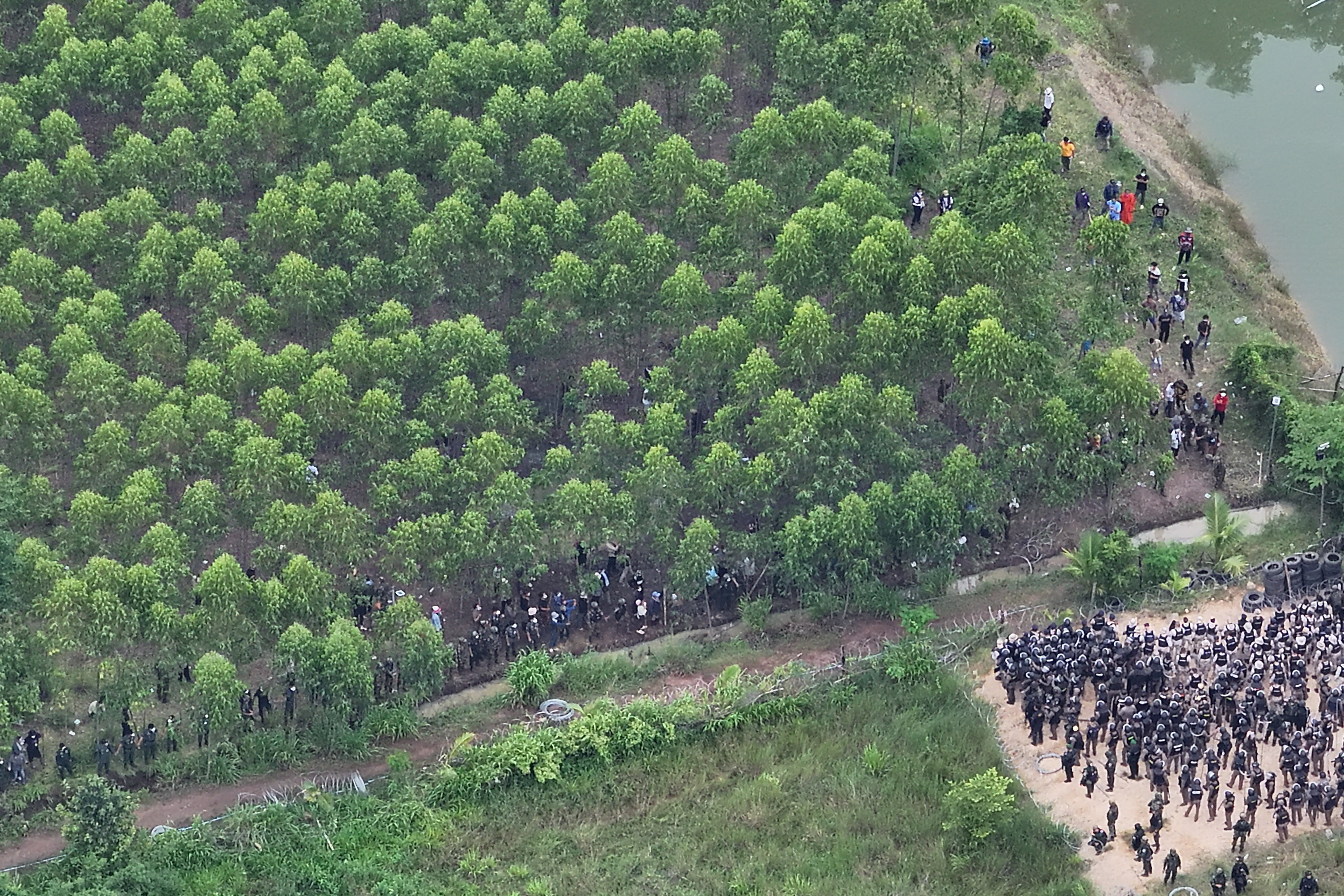 A drone view shows Thai soldiers and riot police officers confronting Cambodian people in a disputed village along the Thailand-Cambodia border in Sa Kaeo province