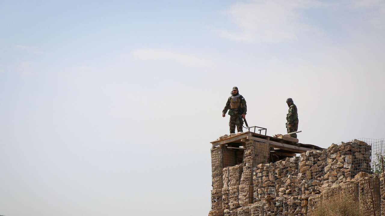 Taliban soldiers stand on top of a their post as they guard near the border, in Khost province