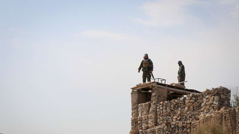 Taliban soldiers stand on top of a their post as they guard near the border, in Khost province