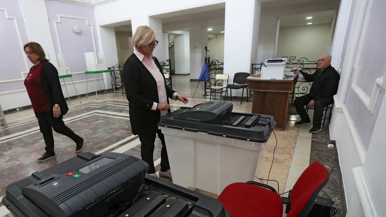 A member of an electoral commission checks a ballot box at a polling station in Tbilisi