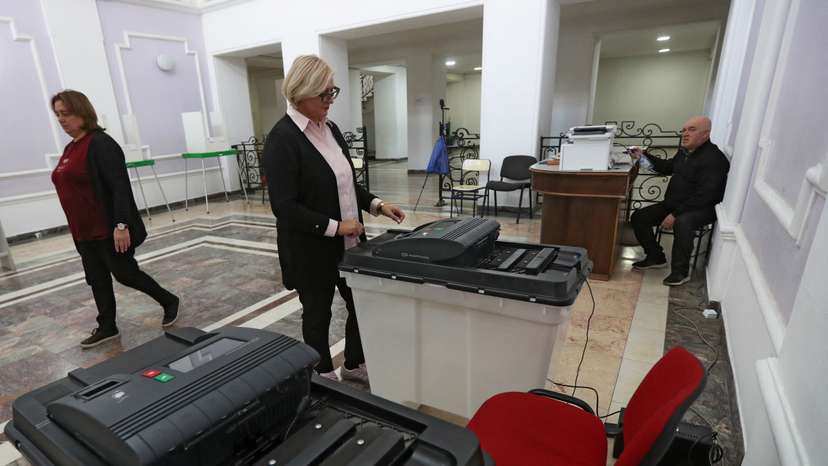 A member of an electoral commission checks a ballot box at a polling station in Tbilisi
