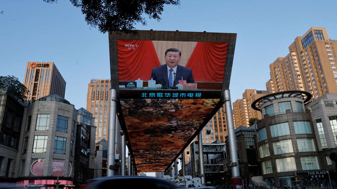 FILE PHOTO: Giant screen shows news footage of the third plenary session of the 20th Central Committee of the Communist Party of China (CPC), in Beijing