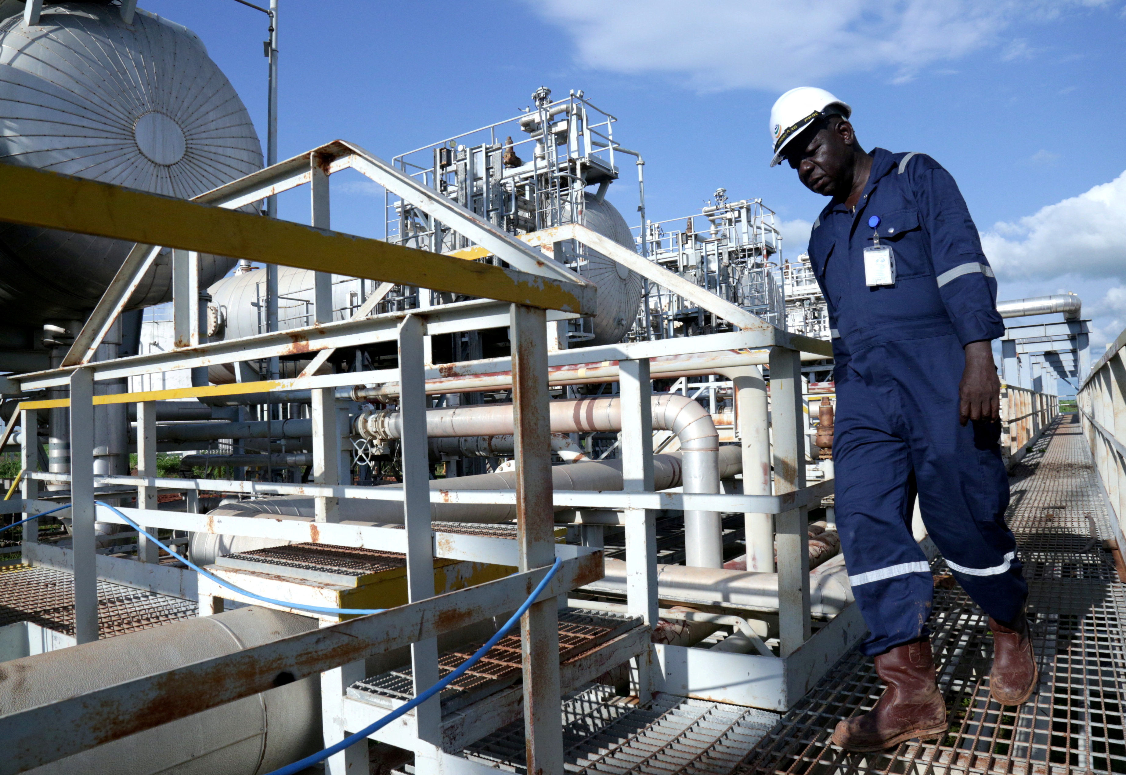 FILE PHOTO: A worker walks by an oil well at the Toma South oil field to Heglig, in Ruweng State
