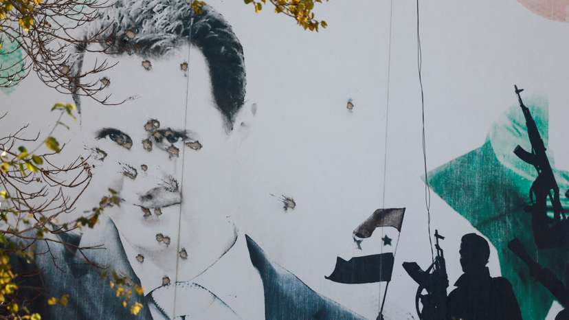 A billboard with a picture of Syria's Bashar al-Assad shows damage by bullet holes, after the ousting of Syria's Bashar al-Assad, in Damascus