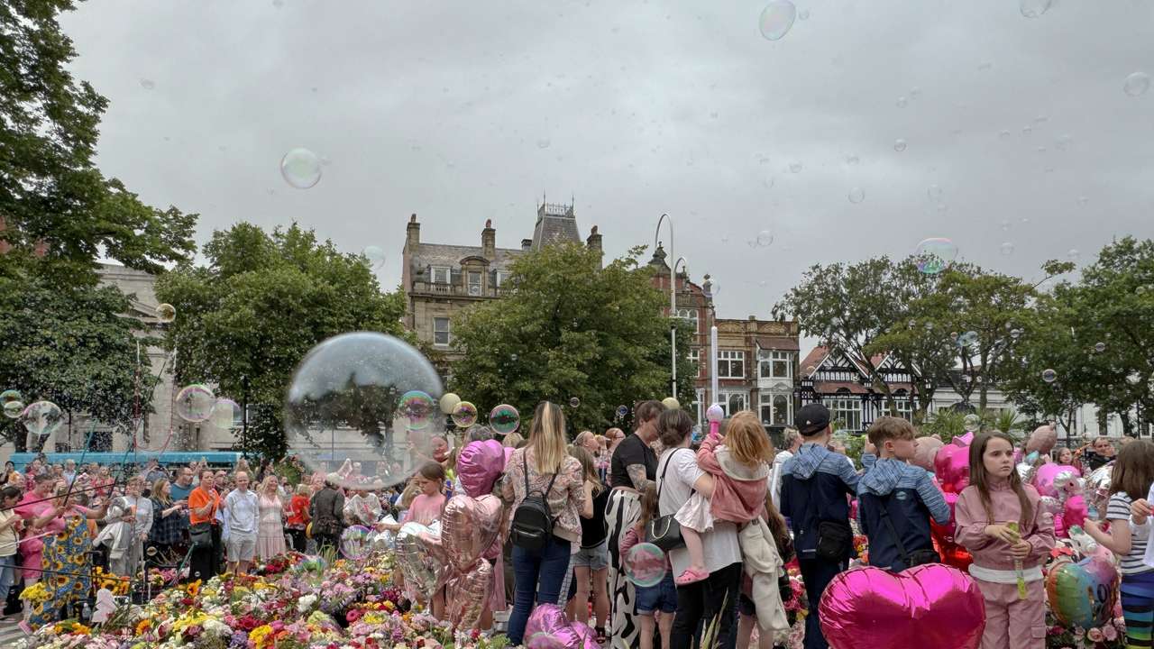 People blow bubbles at the "Kisses to Heaven" tribute to the victims of a knife attack, in Southport