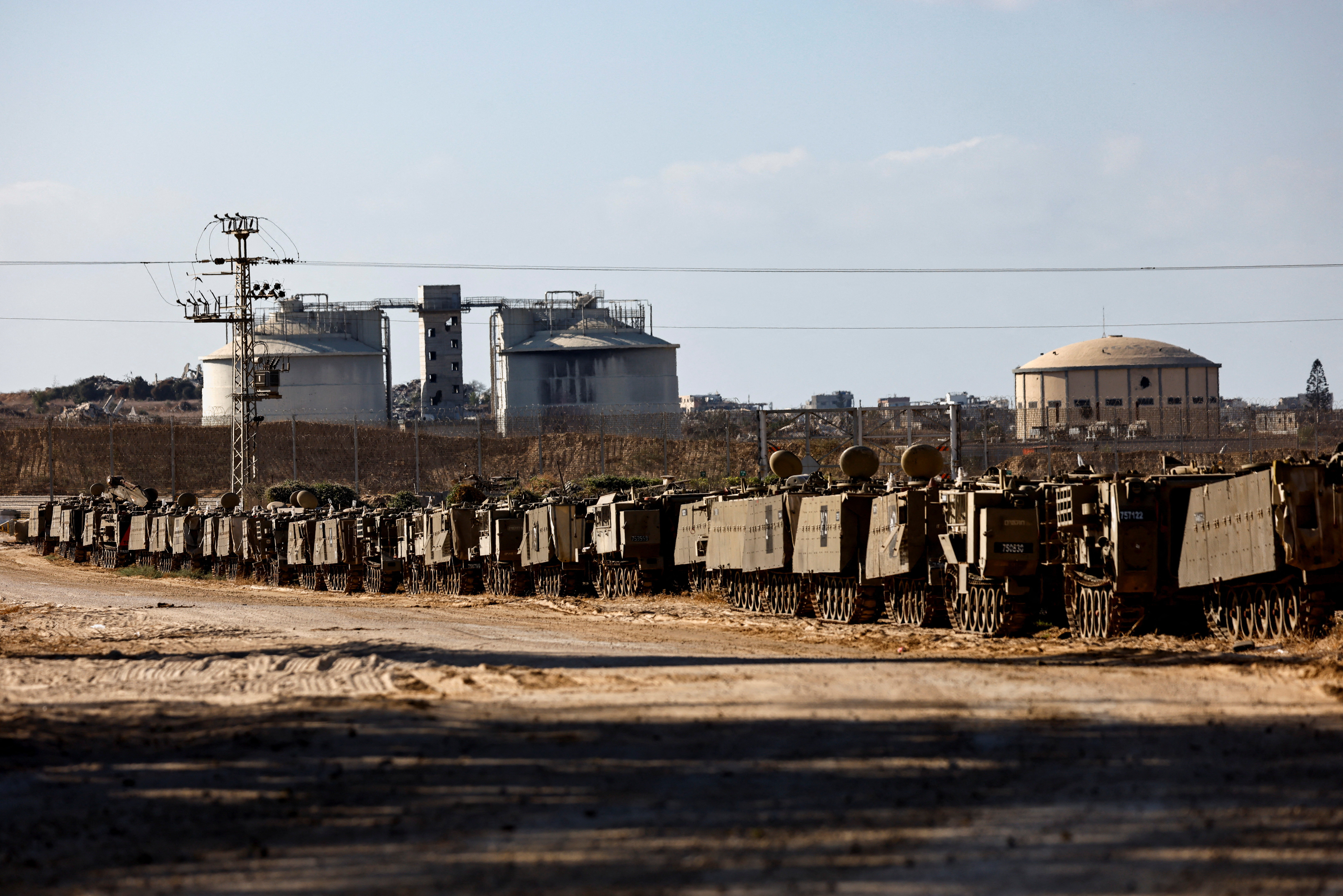 Israeli APCs stand aligned on the Israeli side of the border with Gaza