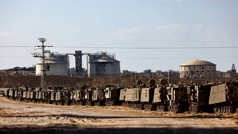 Israeli APCs stand aligned on the Israeli side of the border with Gaza