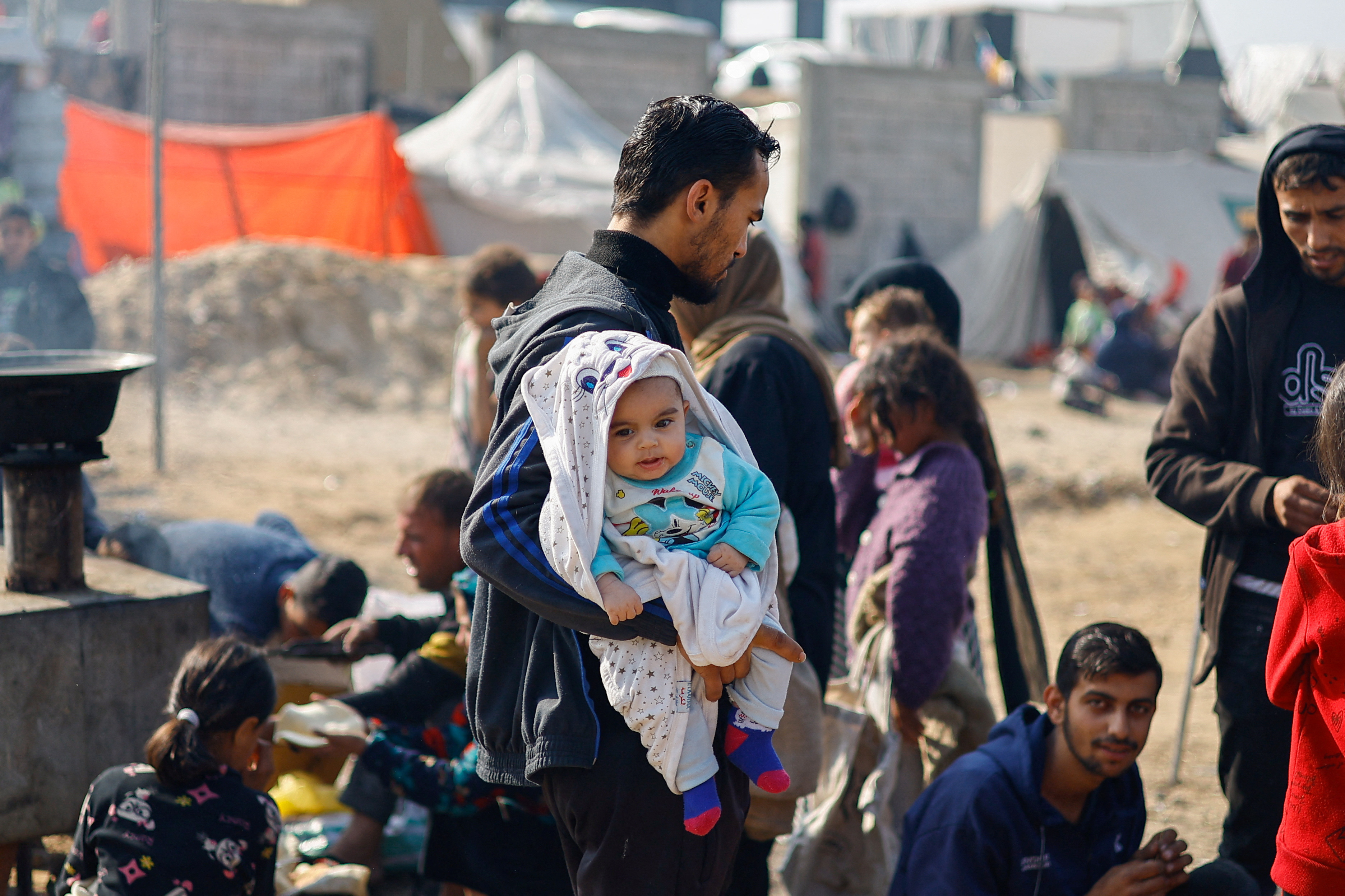 Displaced Palestinians, who fled their homes due to Israeli strikes, shelter in a tent camp in Rafah