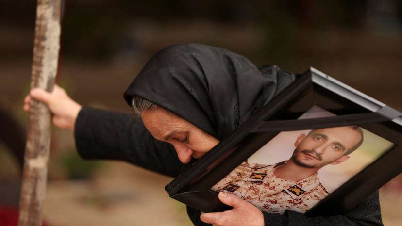 Marzia Rezaei reacts while standing near the grave of her son, Erfan, in Tehran