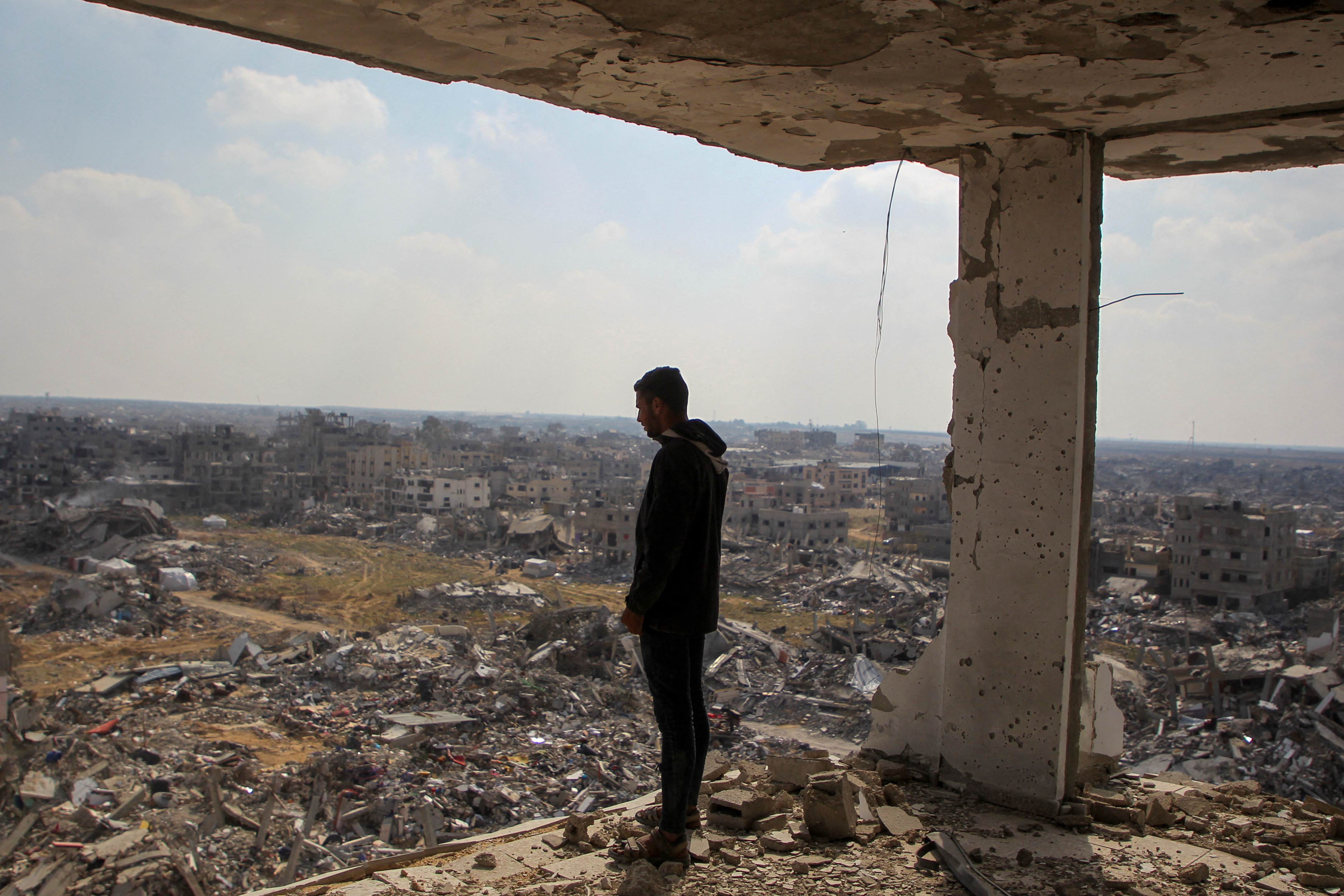 Palestinian man views the rubble of buildings destroyed during the Israeli offensive, amid a ceasefire between Israel and Hamas, in Rafah in the southern Gaza Strip