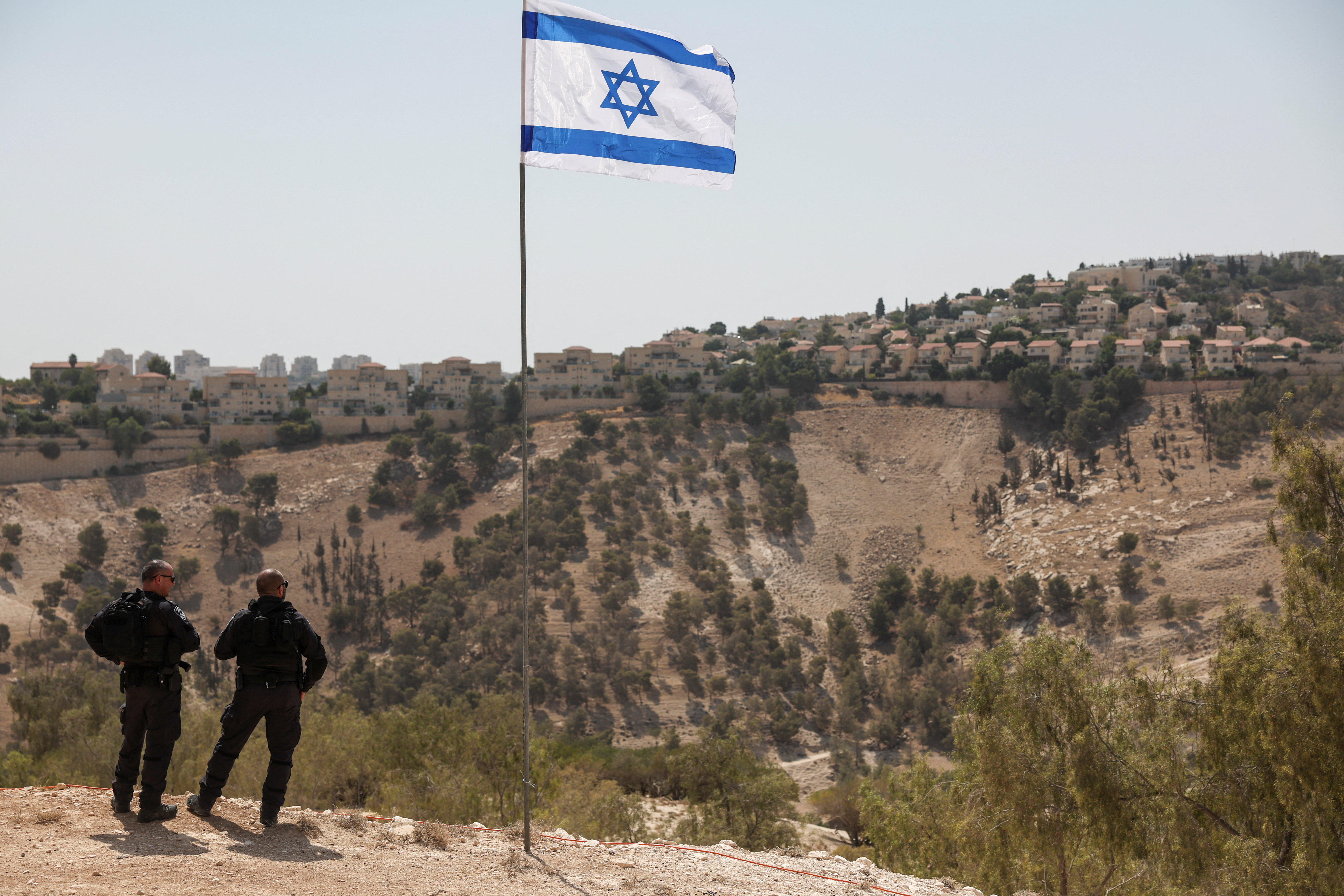 Israeli flag flutters, as part of the Israeli settlement of Maale Adumim is visible in the background, in the Israeli-occupied West Bank