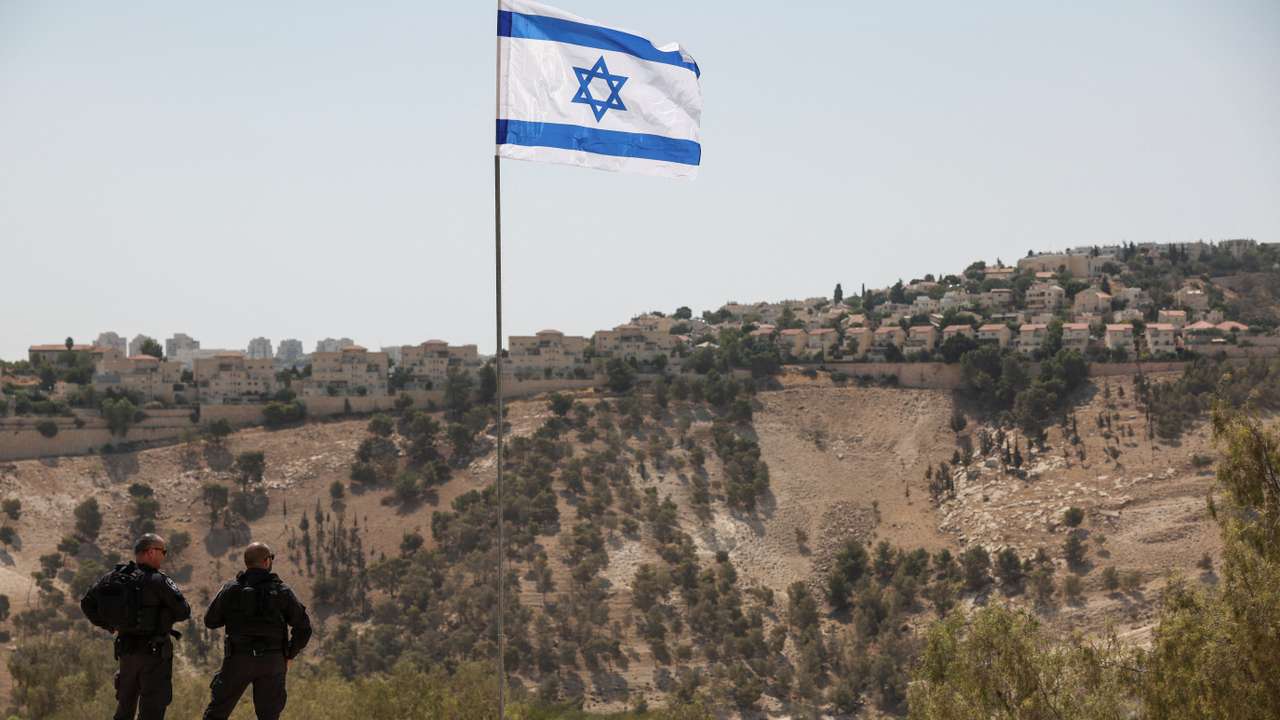 Israeli flag flutters, as part of the Israeli settlement of Maale Adumim is visible in the background, in the Israeli-occupied West Bank
