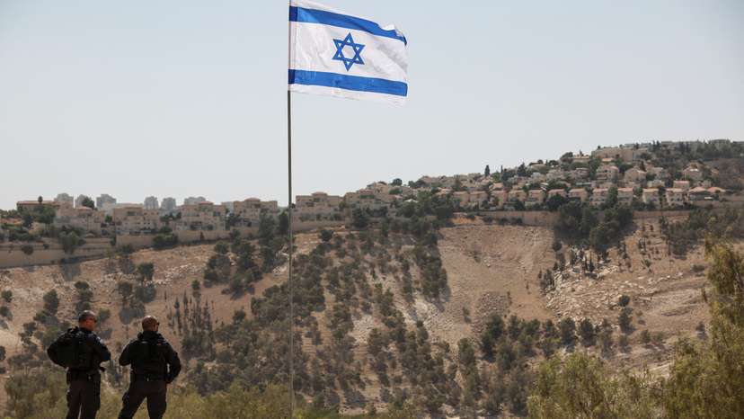 Israeli flag flutters, as part of the Israeli settlement of Maale Adumim is visible in the background, in the Israeli-occupied West Bank