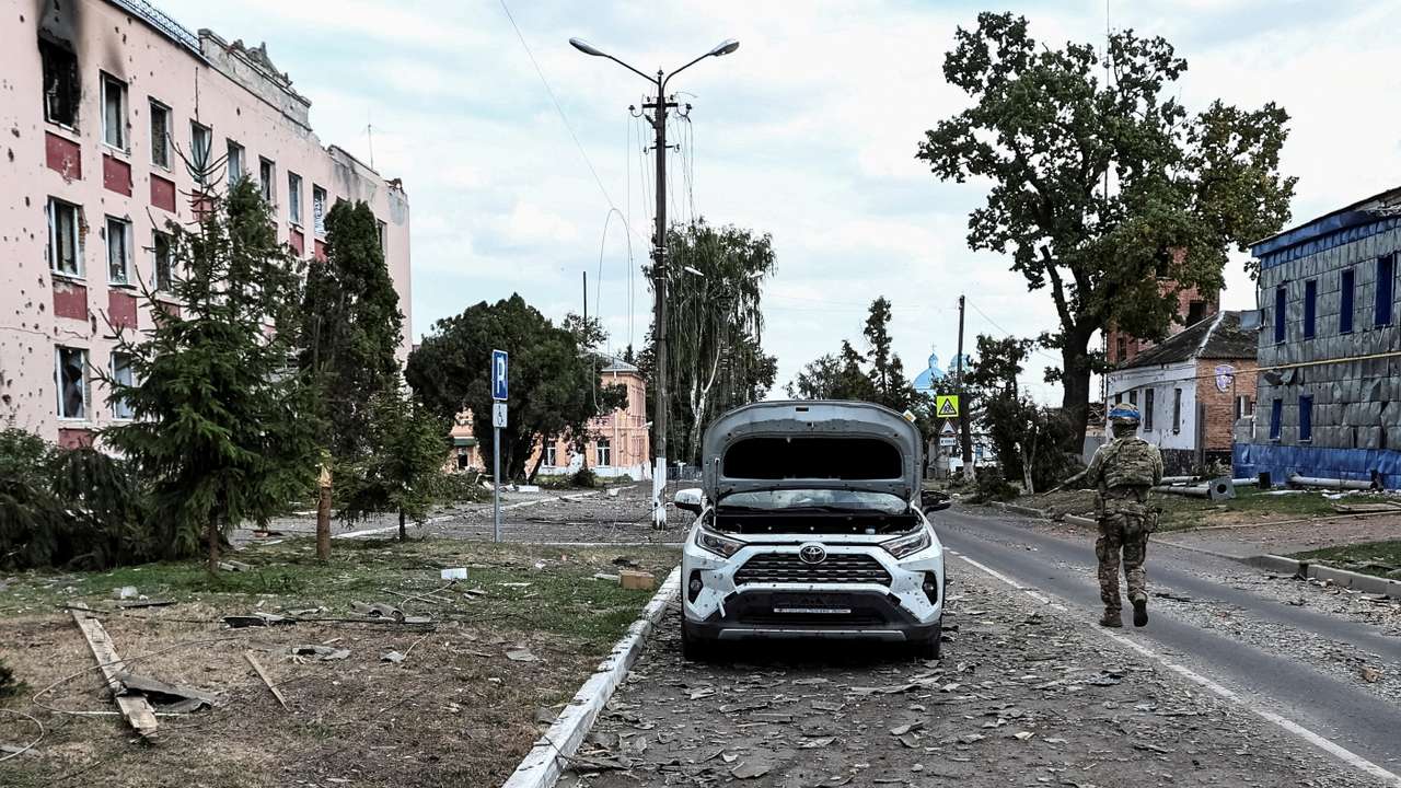 FILE PHOTO: A Ukrainian serviceman patrols a street next to damaged buildings in the town of Sudzha