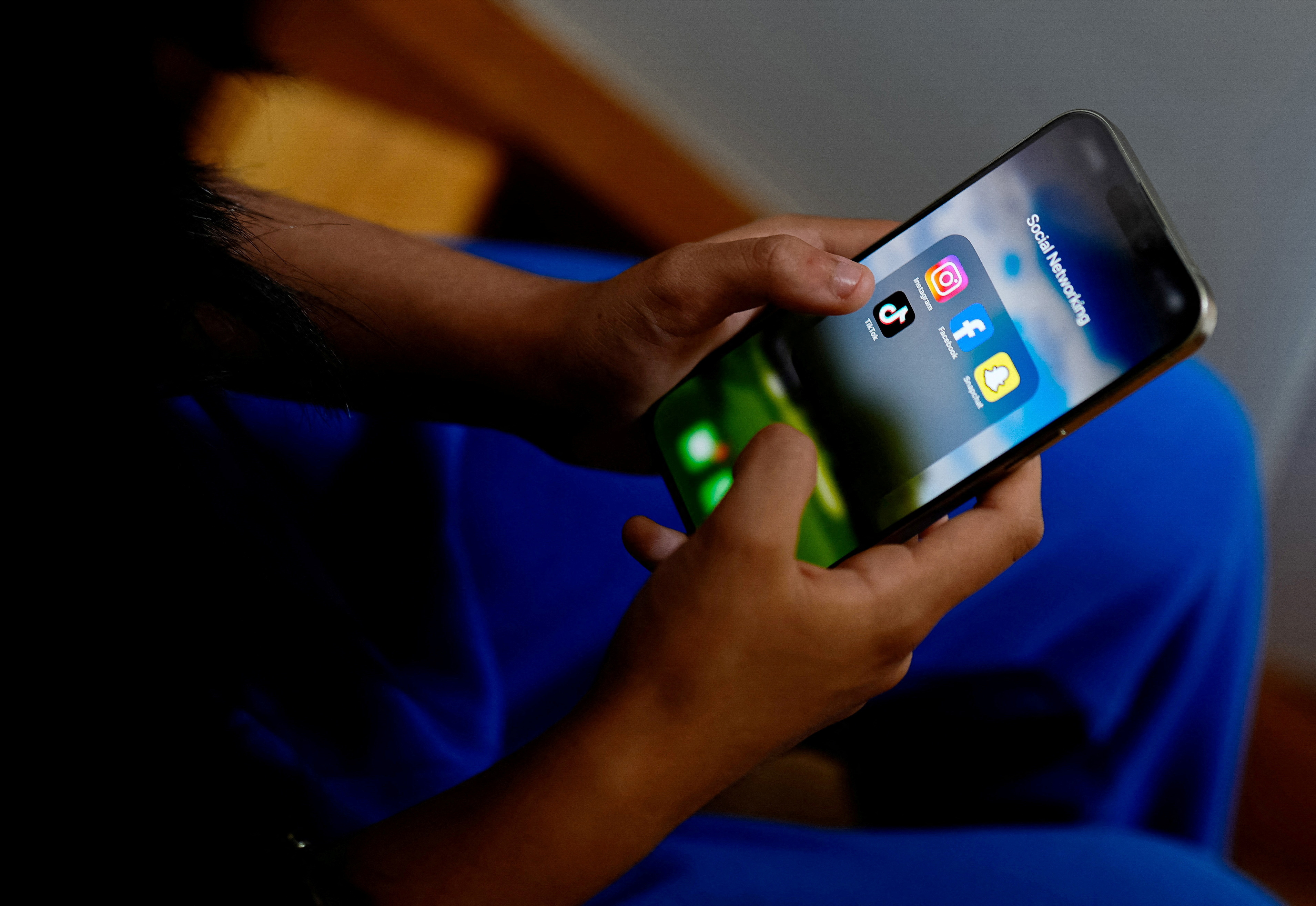 High school student poses with her mobile showing her social media applications in Melbourne