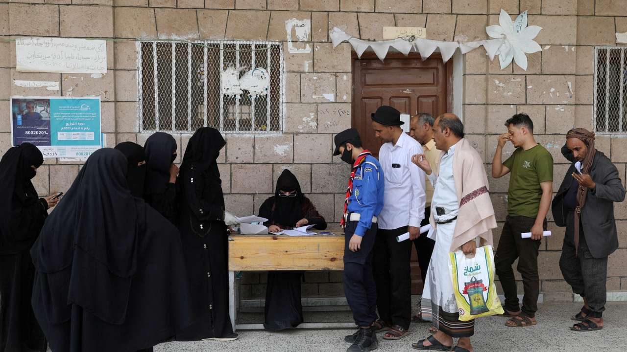 FILE PHOTO: Beneficiaries of World Food Program assistance queue at a food distribution center in Sanaa