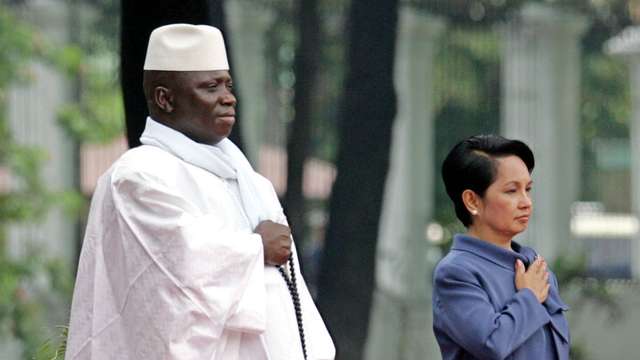 Philippine President Arroyo stands at attention during a welcome ceremony for visiting Gambia ...