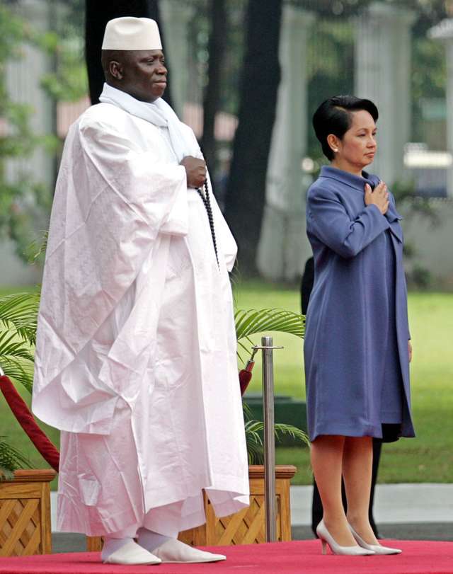 Philippine President Arroyo stands at attention during a welcome ceremony for visiting Gambia ...