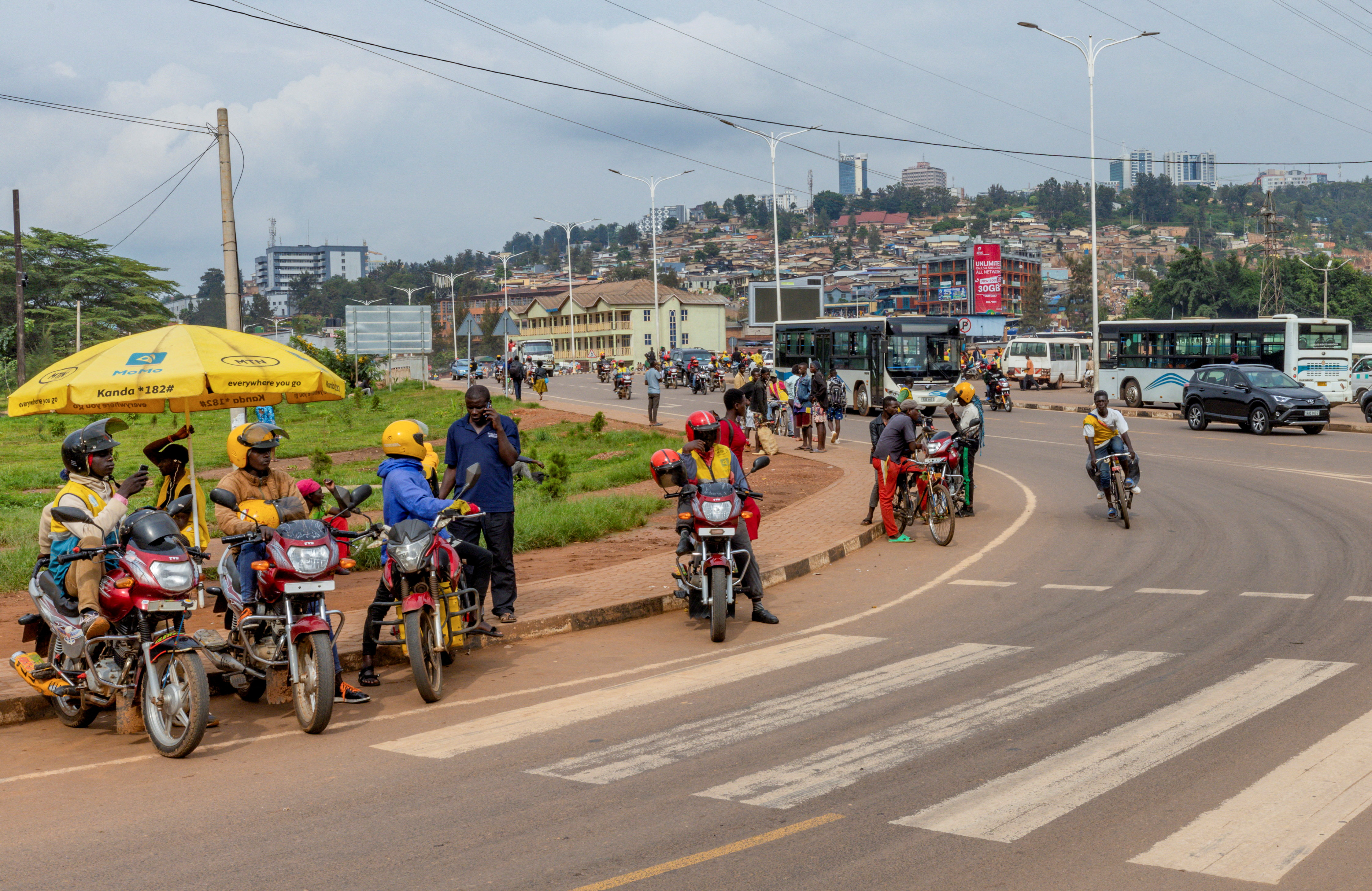Motorists and motorcyclists move along a street in Kigali