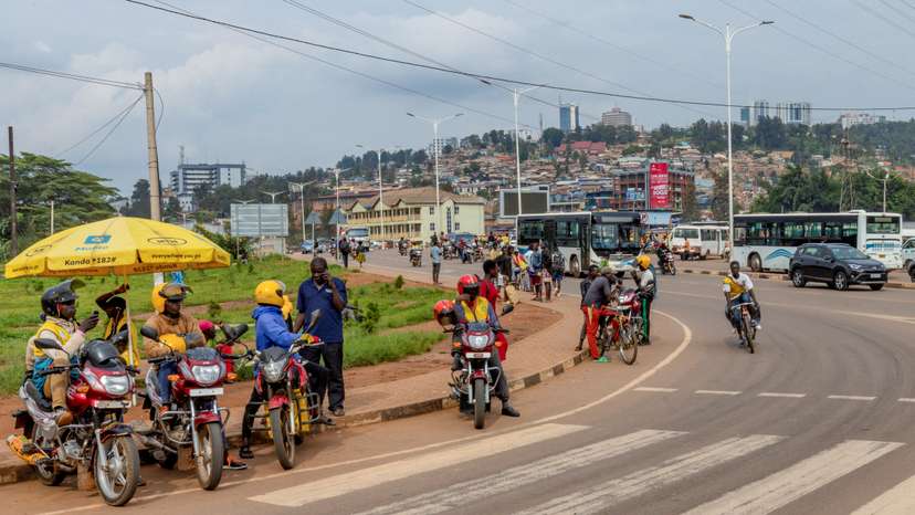 Motorists and motorcyclists move along a street in Kigali
