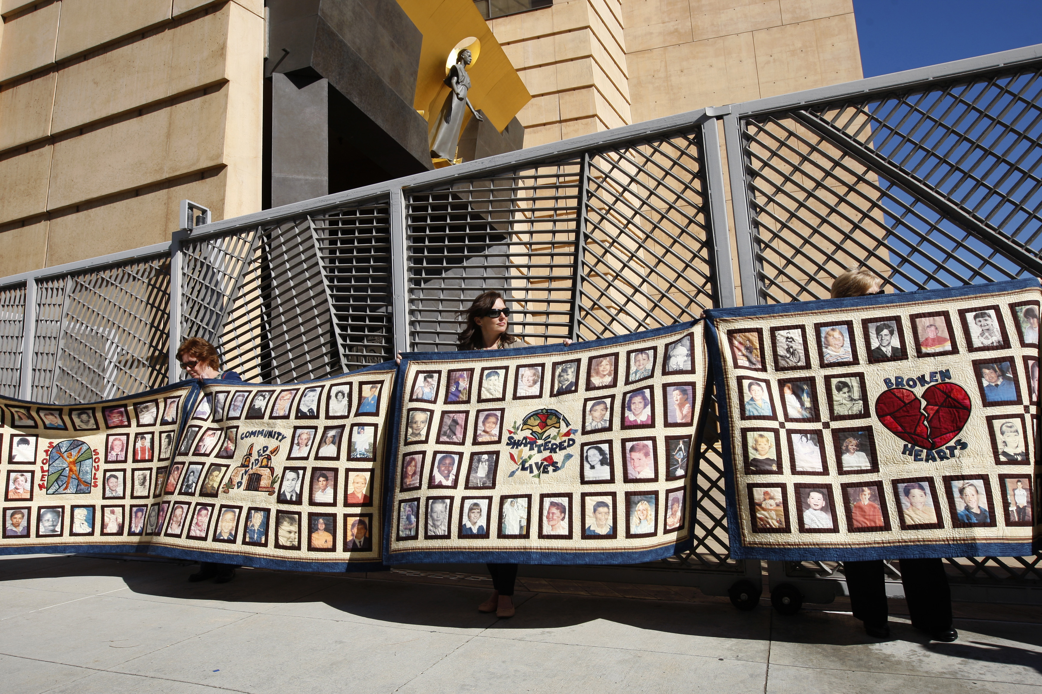 People hold quilts at a press conference outside of Cathedral of Our Lady of the Angels for victims of sexual abuse by priests in the Catholic Archdiocese of Los Angeles