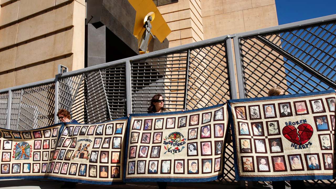 People hold quilts at a press conference outside of Cathedral of Our Lady of the Angels for victims of sexual abuse by priests in the Catholic Archdiocese of Los Angeles