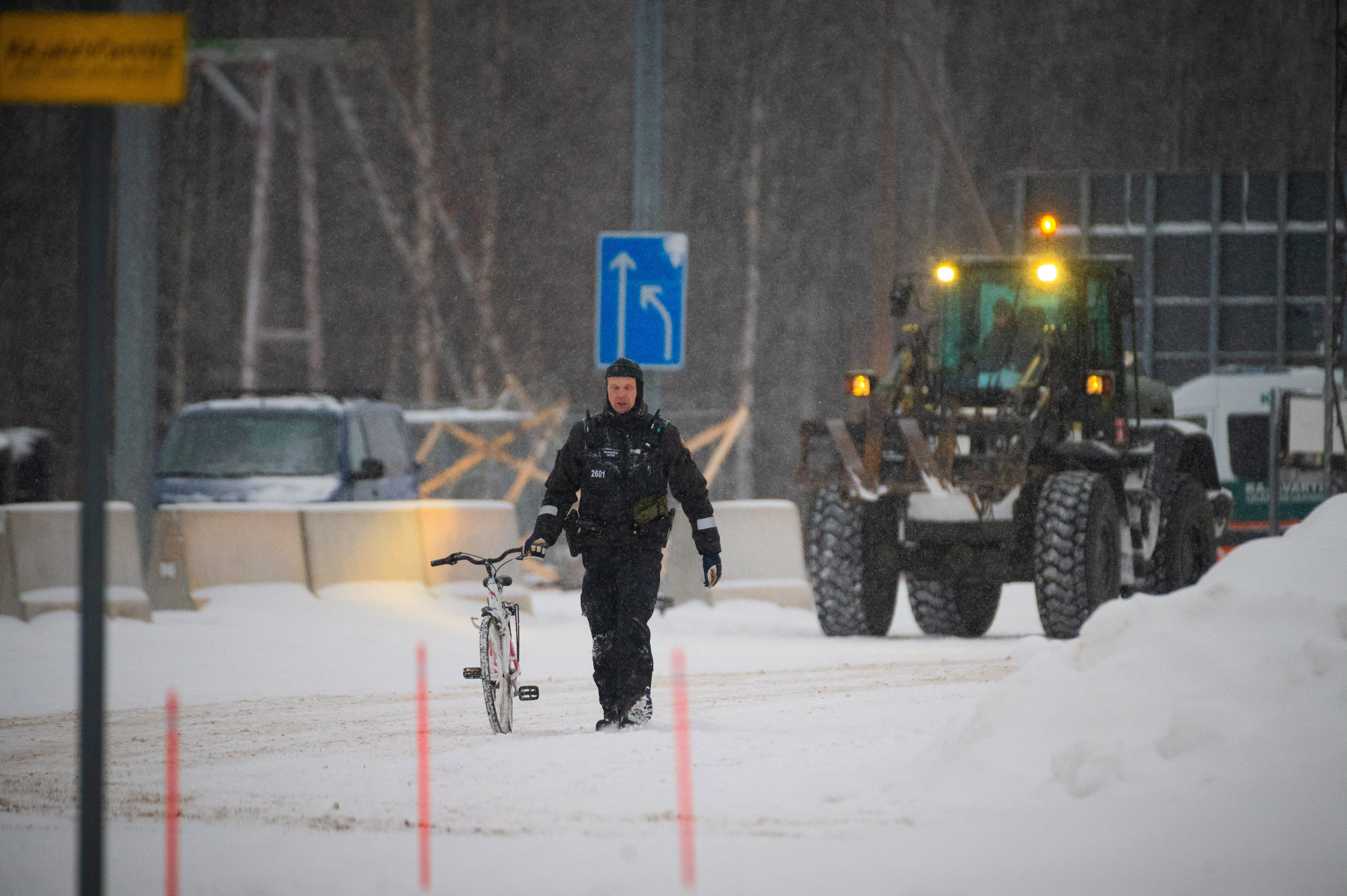 A border guard holds a bicycle of an asylum seeker at the Vartius border station in Kuhmo