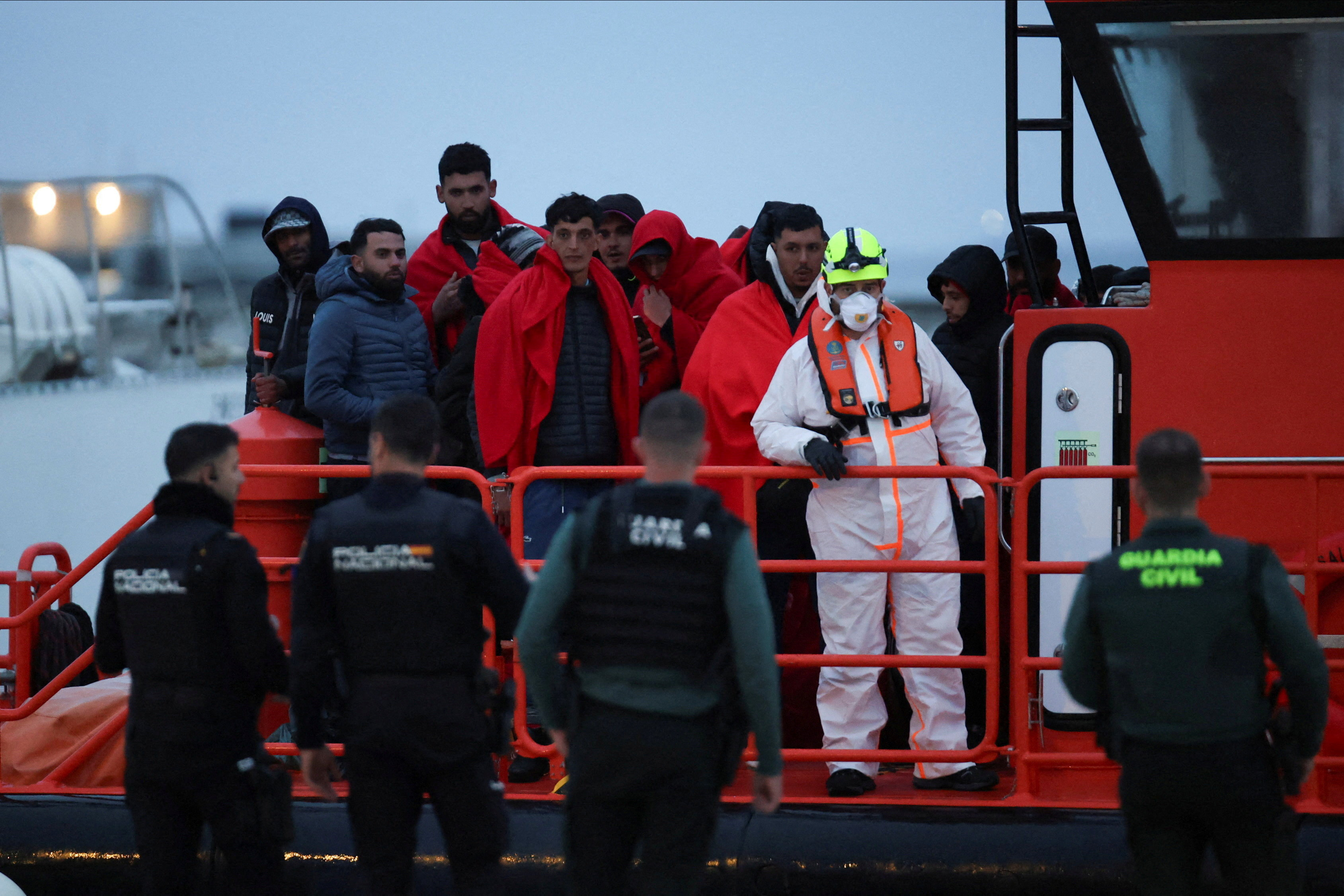 Migrants disembark from a Spanish Coast Guard vessel at the por of Ibiza