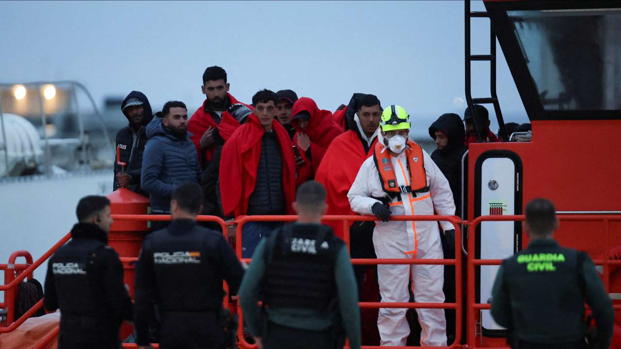 Migrants disembark from a Spanish Coast Guard vessel at the por of Ibiza