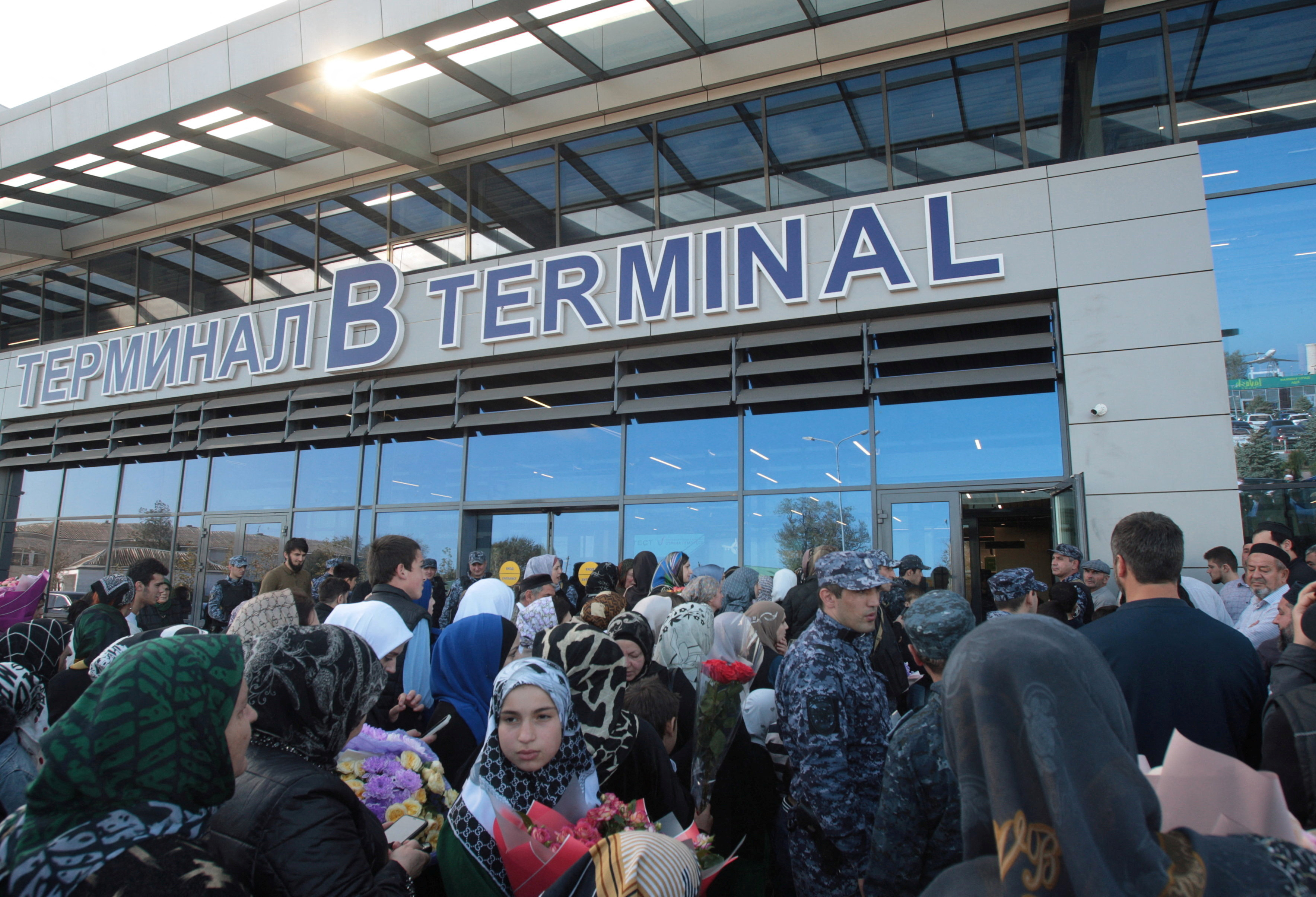 People wait for arriving passengers outside the airport terminal in Makhachkala