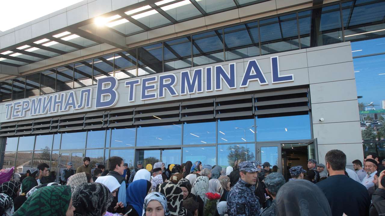 People wait for arriving passengers outside the airport terminal in Makhachkala